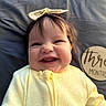 Raylon joined the competition — help win amazing prizes! baby, smiling, yellow_clothing, bow, infant, face, portrait, happy, child, teeth, milestone, three_months, wooden_sign, lying_down, cute, indoors, person, head, young_child, soft_lighting