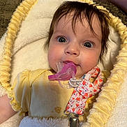 Raylon is registered to the contest to win money with this photo: baby, pacifier, blanket, yellow_clothing, infant, face, eyes, hair, closeup, cute, child, soft_texture, warm, indoors, person, comfort, expression, newborn, clothing, pacifier_clip