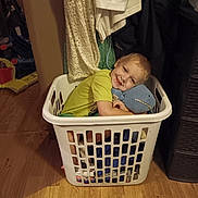 Hunter joined the competition — help win amazing prizes! child, boy, laundry_basket, stuffed_animal, toy, smiling, indoor, wooden_floor, clothing, fabric, home, cute, happy, person, casual, playful, cozy, yellow_shirt, blue_toy, relaxed