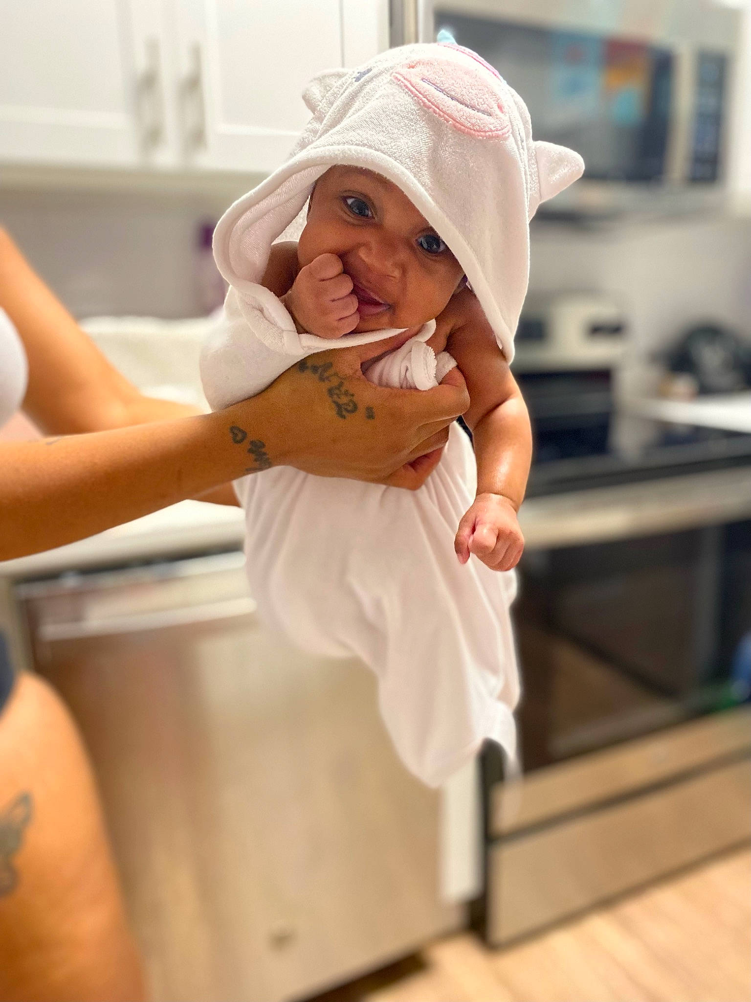Winterlynn is registered to the contest to win money with this photo: abdomen, baby, cap, child, comfort, elbow, event, flooring, gesture, happy, headgear, headwear, human_leg, kitchen_appliance, knee, person, room, shoulder, sitting, smile