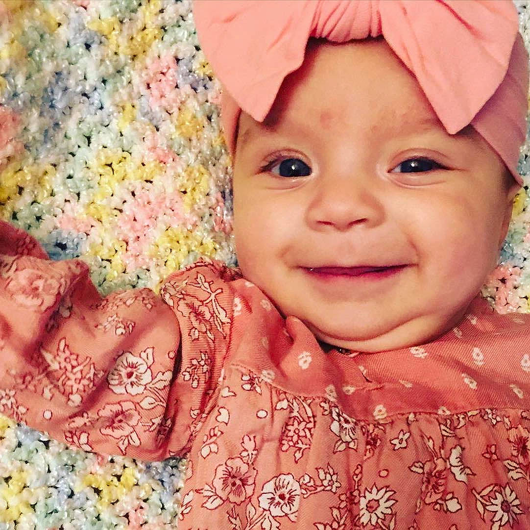 Alexandra is registered to the contest to win money with this photo: baby_toddler_clothing, cheek, chin, clothing, dress, eye, face, facial_expression, happy, head, headwear, iris, joy, lip, nose, outerwear, person, photograph, pink, skin