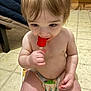toddler, child, diaper, popsicle, floor, indoor, sitting, happy, cute, food, snack, hair, skin, hand, face, eyes, mouth, toys, cushion, clothing