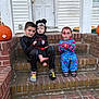 child, children, costume, halloween, face_paint, pumpkin, brick, steps, door, house, porch, socks, mickey_mouse, pajamas, outdoor, fall, leaf, smiling, sitting, group