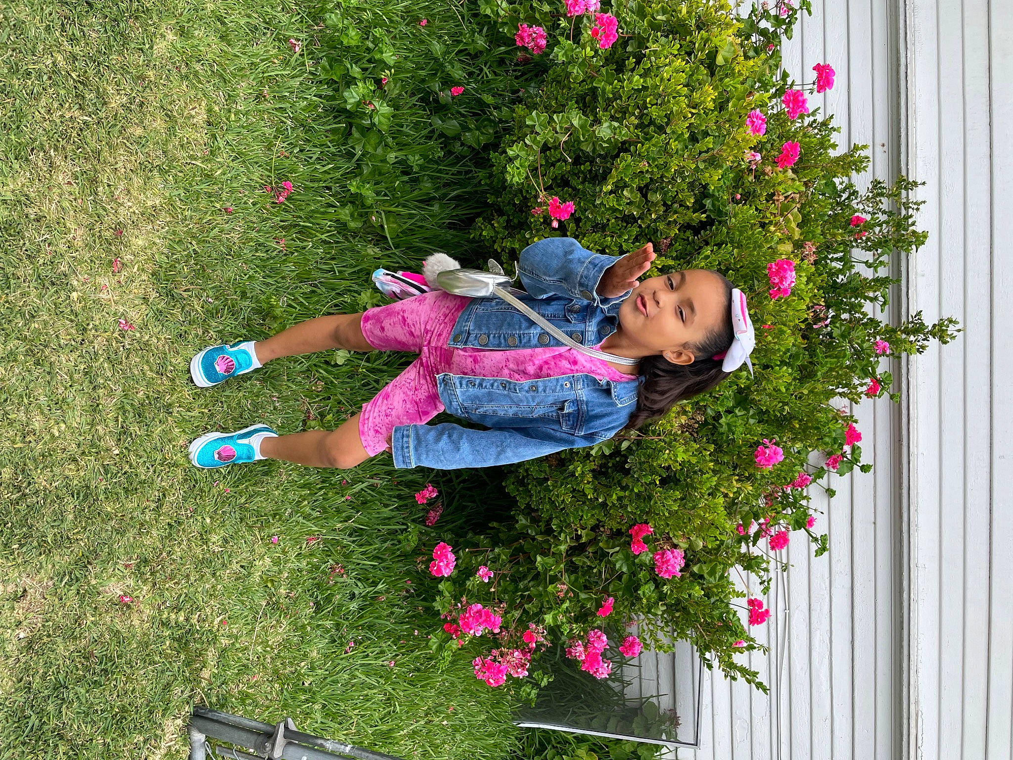 Jaylani is registered to the contest to win money with this photo: annual_plant, child, fence, floral_design, flower, flowering_plant, fun, garden, grass, groundcover, happy, leisure, magenta, people_in_nature, person, petal, pink, plant, recreation, shrub