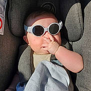 Roxane participe au concours pour gagner de l'argent avec cette photo : baby, baby_accessory, blanket, car_seat, child, clothing, cozy, cute, face, hand, indoor, infant, portrait, relaxing, seatbelt, shadow, small_person, soft_texture, sunglasses, sunlight