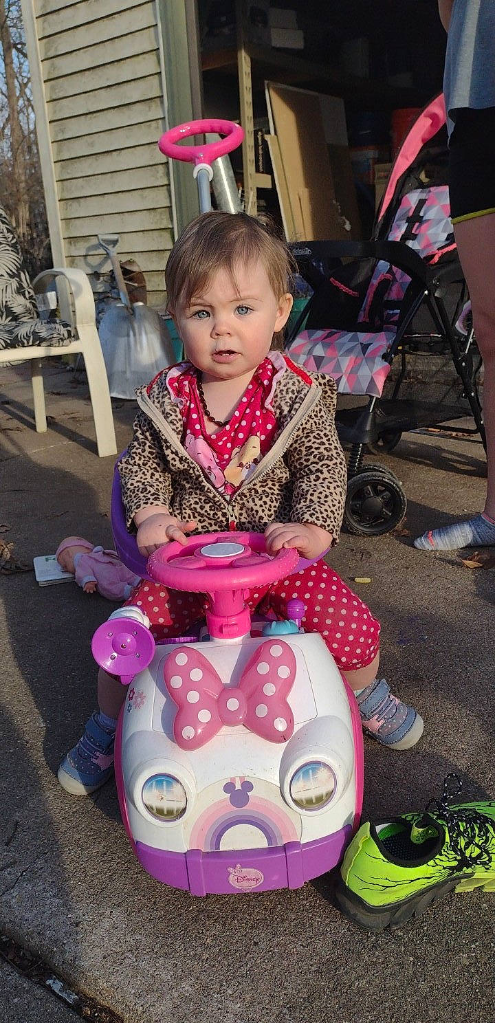Delaney is registered to the contest to win money with this photo: chair, child, event, fun, happy, leisure, magenta, people, person, photograph, pink, product, purple, recreation, riding_toy, shoe, sitting, snapshot, toddler, toy