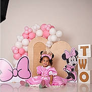 Silvia is registered to the contest to win money with this photo: balloons, birthday, blocks, cartoon, celebration, child, costume, cute, decorations, floor, happy, headband, indoor, minnie_mouse, party, pink_dress, portrait, sitting, smile, toddler