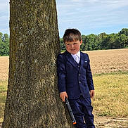 Ryder-Gene is registered to the contest to win money with this photo: boy, casual, child, daylight, field, fun, grass, nature, outdoor, person, playful, portrait, shoes, sky, smiling, standing, suit, toy_gun, tree, young