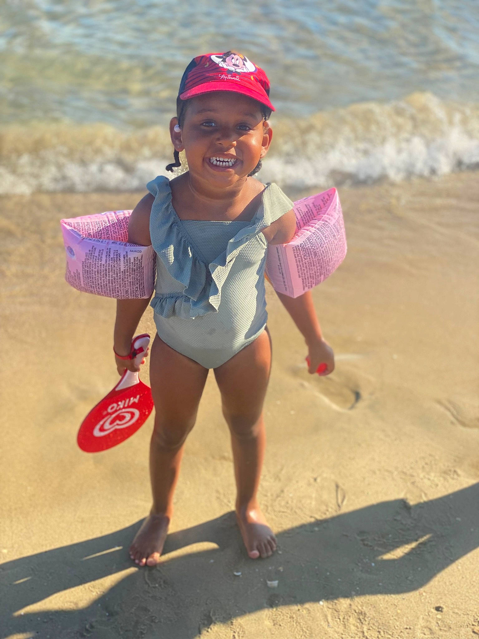 Janélya a rejoint le concours — aidez-le/la à gagner de superbes lots ! barefoot, baseball_cap, beach, body_of_water, cap, fun, happy, hat, headwear, joy, leg, leisure, people_on_beach, person, recreation, sand, shore, shorts, smile, standing