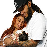 Yarieliz joined the competition — help win amazing prizes! baby, infant, adults, family, parents, portrait, cuddling, sleeping, smiling, affection, indoor, white_background, baseball_cap, beard, dreadlocks, long_hair, tattoos, floral_blanket, white_shirt, family_photo