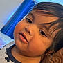 Jack is registered to the contest to win money with this photo: toddler, child, face, portrait, indoor, curly_hair, close_up, expression, soft_lighting, blue_curtain, shirt, person, young_child, skin, head, cute, chubby_cheeks, looking, hair, warm