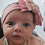 baby, infant, face, headband, pink, bow, clothing, wide_eyes, curious, portrait, close_up, child, skin, hand, young, indoors, cute, expression, person, newborn