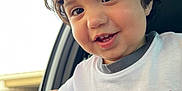 Jesús joined the competition — help win amazing prizes! toddler, child, curly_hair, smiling, white_tshirt, logo, lee_brand, car_interior, window, door_handle, bracelet, happy, portrait, young_child, close_up, casual_clothing, cute, person, indoor, daylight