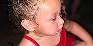 Zelyiana is registered to the contest to win money with this photo: child, toddler, curly_hair, red_clothing, close_up, portrait, face, skin, expression, person, young_child, cute, indoors, blurry_background, soft_lighting, hair_tied_up, casual, sitting, looking_away, profile_view