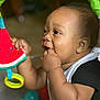 Djuantay joined the competition — help win amazing prizes! baby, background_blur, black_clothing, child, closeup, colorful, cute, early_childhood, expression, face, hand, happy, indoor, infant, person, playing, plush_toy, smiling, toy, watermelon
