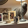 animal, cat, cozy, curious, dog_photo, dresser, furniture, gray_cat, home_decor, indoor, lamp, lighting, mug, pet, photo_frame, reflection, round_mirror, table_lamp, tabletop, white_furniture