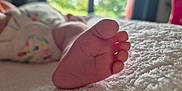 Lana a rejoint le concours — aidez-le/la à gagner de superbes lots ! baby_foot, infant, close_up, soft_texture, blanket, bed, natural_light, blurred_background, indoor, foot, skin, toes, baby_clothing, sleeping_baby, peaceful, cozy, newborn, resting, soft_light, window