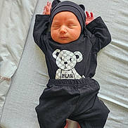 Daéron participe au concours pour gagner de l'argent avec cette photo : newborn, baby, sleeping, black_clothing, hat, teddy_bear_print, bed, blanket, infant, cute, peaceful, resting, indoors, soft_light, small_hands, small_feet, lying_down, child, portrait, cozy