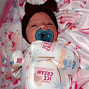 Adelina is registered to the contest to win money with this photo: baby, pacifier, headband, onesie, blanket, infant, sleepy, patterned_clothing, pink, white, lying_down, face, cute, soft_texture, cozy, child, small, newborn, indoors, wearing