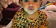 Lilly-Rae is registered to the contest to win money with this photo: child, toddler, baby, highchair, leopard_print, sweater, hair_bows, wide_eyes, surprised_expression, hands, earrings, indoor, living_room, couch, blanket, painting, lamp, toy, portrait, closeup