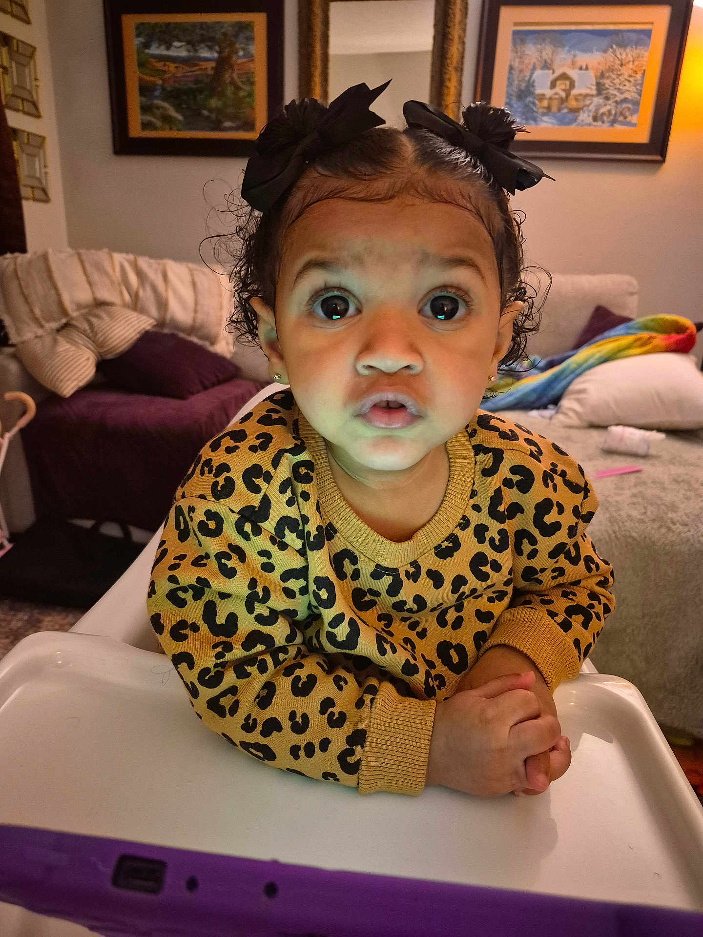 Lilly-Rae joined the competition — help win amazing prizes! child, toddler, baby, highchair, leopard_print, sweater, hair_bows, wide_eyes, surprised_expression, hands, earrings, indoor, living_room, couch, blanket, painting, lamp, toy, portrait, closeup