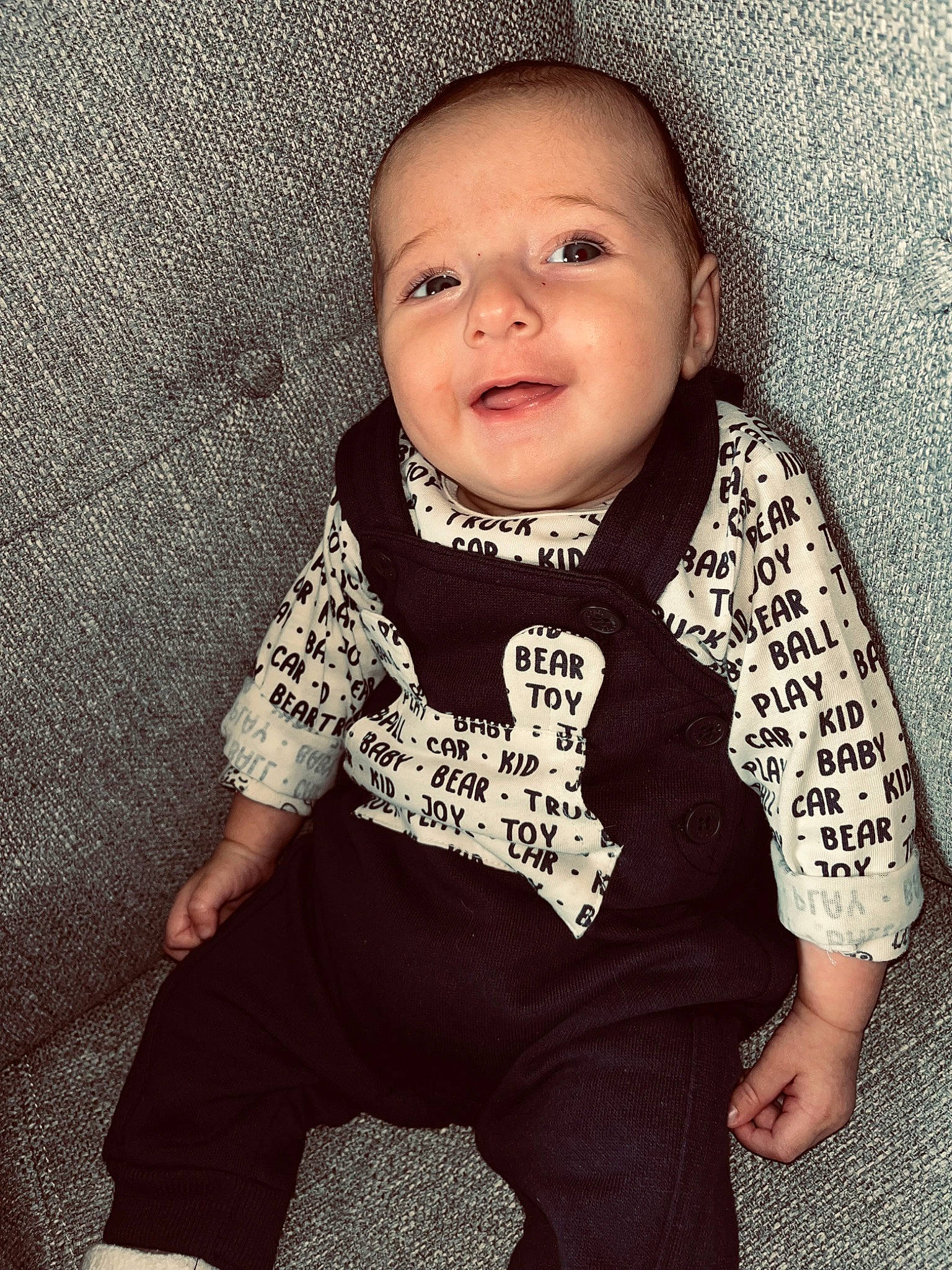 Raphael participe au concours pour gagner de l'argent avec cette photo : arm, baby, baby_toddler_clothing, cheek, cool, face, flash_photography, grey, happy, head, human_body, iris, lip, neck, nose, outerwear, person, skin, sleeve, smile