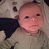 Noah is registered to the contest to win money with this photo: baby, infant, face, eyes, plush_toy, panda, soft_toy, clothing, cozy, blanket, child, cute, portrait, indoors, sleepwear, newborn, expression, resting, head, skin