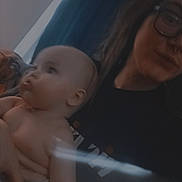 Skarlett joined the competition — help win amazing prizes! baby, person, indoor, curtain, glasses, shirt, holding, portrait, child, face, diaper, furniture, wall, picture_frame, window, dark, blur, smile, hair, skin