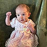 Vivian joined the competition — help win amazing prizes! baby, infant, pink_dress, curious, raised_fists, green_blanket, cute, portrait, small_feet, happy, indoors, child, soft_texture, young, sitting, adorable, clothing, smiling, person, closeup