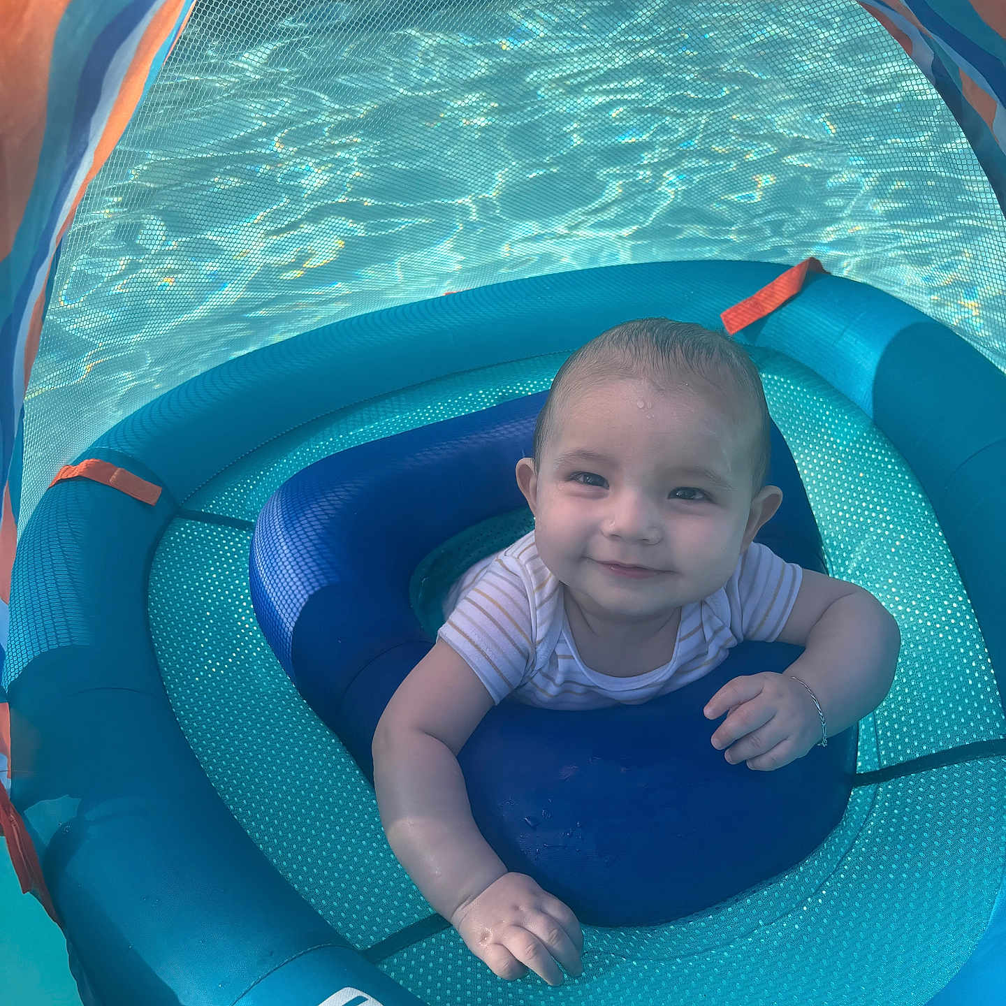 Adriel is registered to the contest to win money with this photo: baby, child, swim_float, pool, water, smile, happy, blue, canopy, sunlight, outdoor, infant, sitting, floating, playful, summer, water_reflection, person, cute, swimming