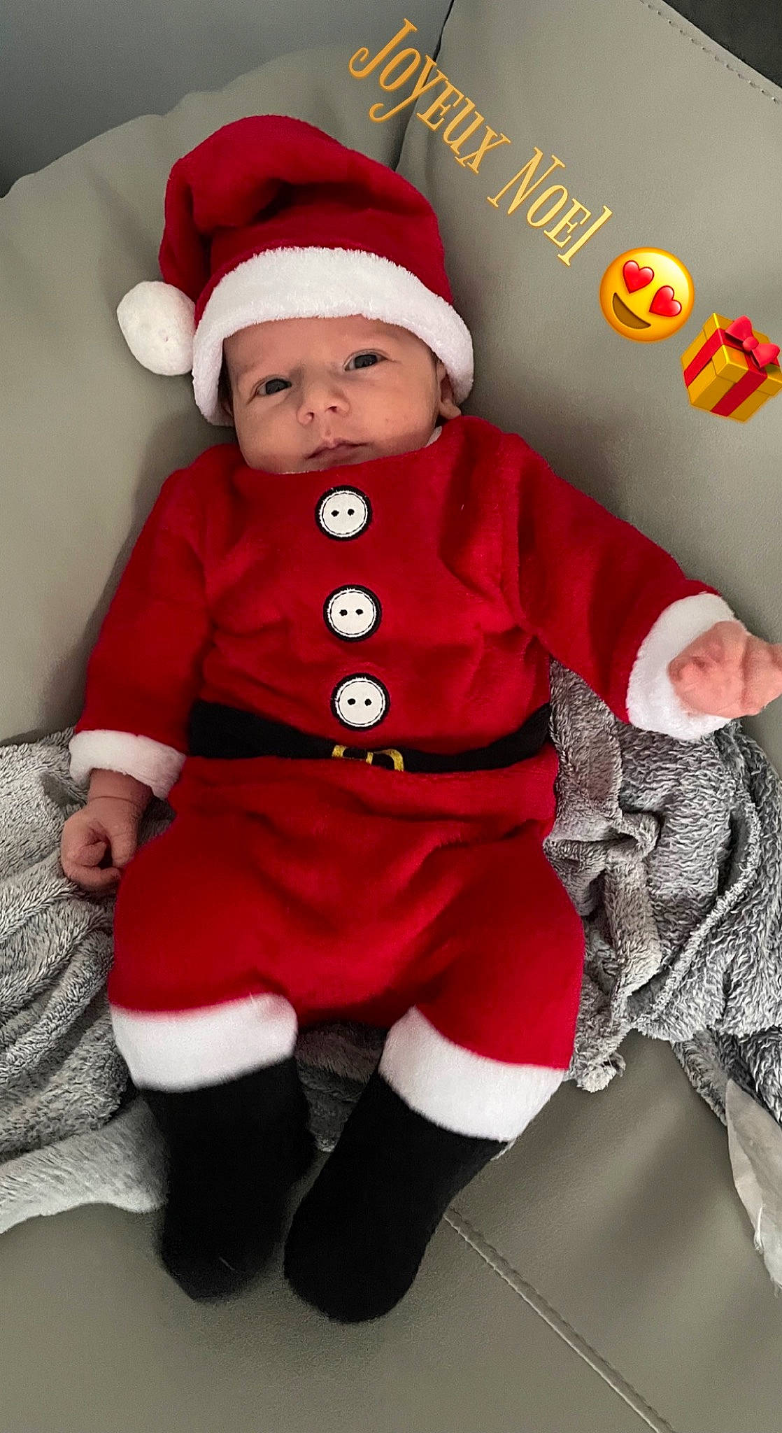 Milann participe au concours pour gagner de l'argent avec cette photo : baby, baby_toddler_clothing, christmas_decoration, costume_hat, event, face, fictional_character, fur_clothing, hat, headwear, holiday, human_body, lap, organ, outerwear, person, red, santa_claus, sleeve, sock