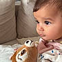 baby, infant, toddler, couch, sofa, cushion, plush_toy, stuffed_animal, blanket, hand, face, eyes, eyelashes, cheeks, nose, closeup, indoor, home, soft_texture, gaze