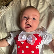 Fiona joined the competition — help win amazing prizes! arms_outstretched, baby, blanket, cheeks, child, cute, face, happy, head, indoor, infant, light, lying_down, mouth_open, polka_dots, portrait, red_bow, smiling, soft_texture, white_shirt