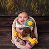 baby, child, plush_toy, duck, smiling, laughing, sitting, soft_chair, wooden_floor, background, colorful, cute_outfit, happy, indoor, portrait, infant, toy, fabric, comfort, playful