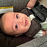 baby, infant, car_seat, face, straps, drool, child, warning_label, curious, closeup, seatbelt, cute, indoors, head_support, fabric, person, smiling, young_child, portrait, safety