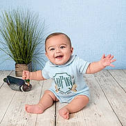 Brayden joined the competition — help win amazing prizes! baby, bare_feet, blue_background, child, decorative_duck, face, happy, houseplant, indoor, infant, onesie, outfit, photography, portrait, sitting, smiling, studio, toy, waving, wooden_floor