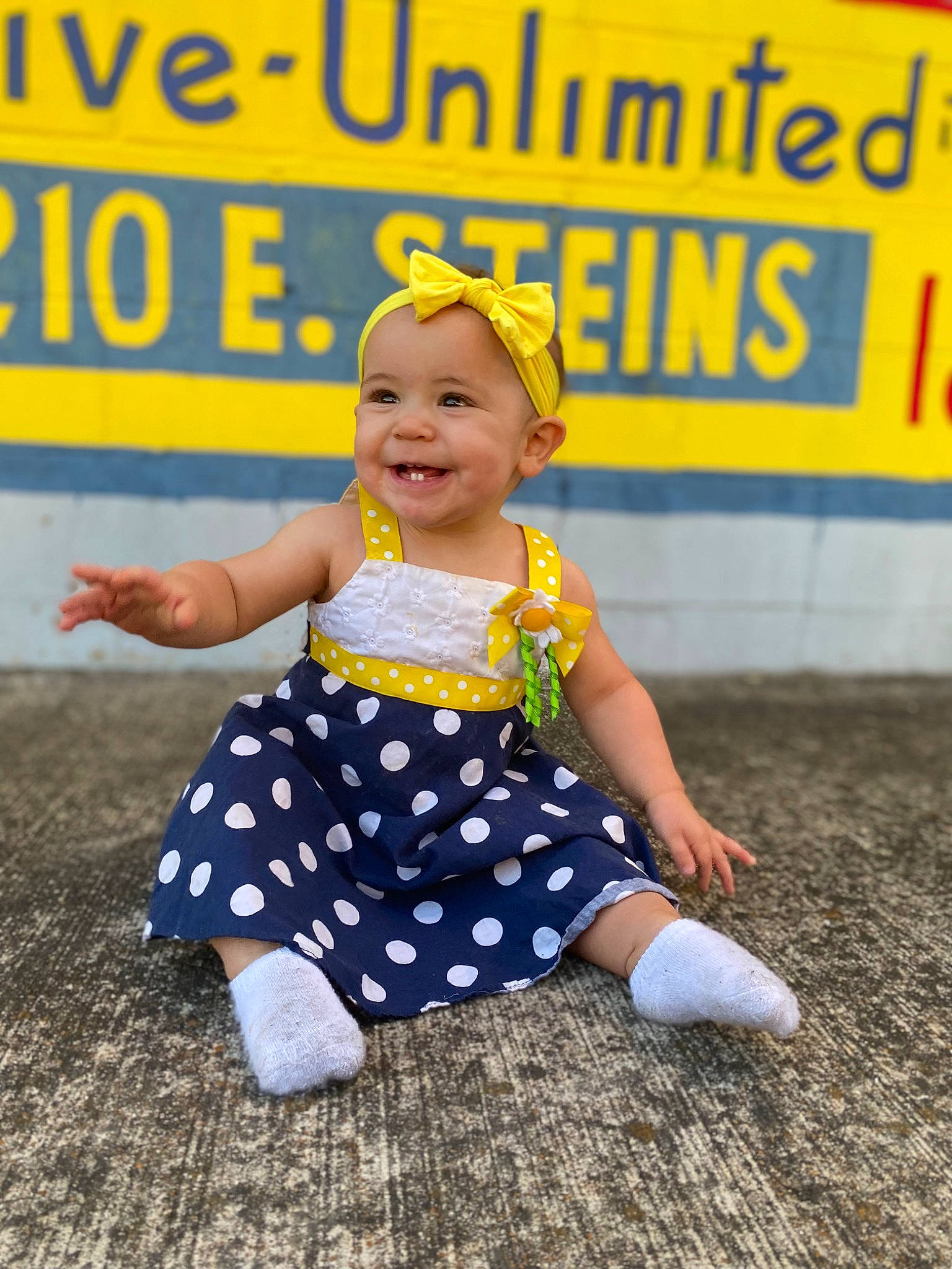 Lorelai is registered to the contest to win money with this photo: baby, baby_toddler_clothing, barefoot, child, entertainment, event, fun, happy, headwear, human_leg, joy, leisure, logo, pattern, performing_arts, person, play, polka_dot, recreation, sitting