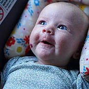 Willow joined the competition — help win amazing prizes! baby, infant, face, smile, blue_eyes, cushion, floral_pattern, clothing, close_up, portrait, child, cute, happy, indoor, soft_lighting, newborn, skin, head, expression, comfort