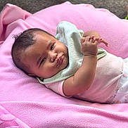 Azalea is registered to the contest to win money with this photo: baby, child, closeup, clothing, comfortable, cozy, cute, expression, face, hands, head, indoor, infant, lying_down, newborn, person, pink_blanket, portrait, skin, soft_texture