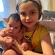 Kehlani joined the competition — help win amazing prizes! child, baby, girl, tiara, angel_wings, necklace, yellow_shirt, pink_outfit, indoor, holding, smiling, portrait, cute, siblings, playful, happy, infant, family, person, love