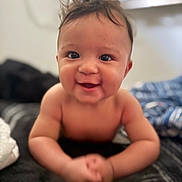 Azariah is registered to the contest to win money with this photo: baby, smiling, face, child, cute, infant, skin, happy, portrait, toddler, lying_down, hands, arms, indoors, blurred_background, expression, hair, young, person, closeup