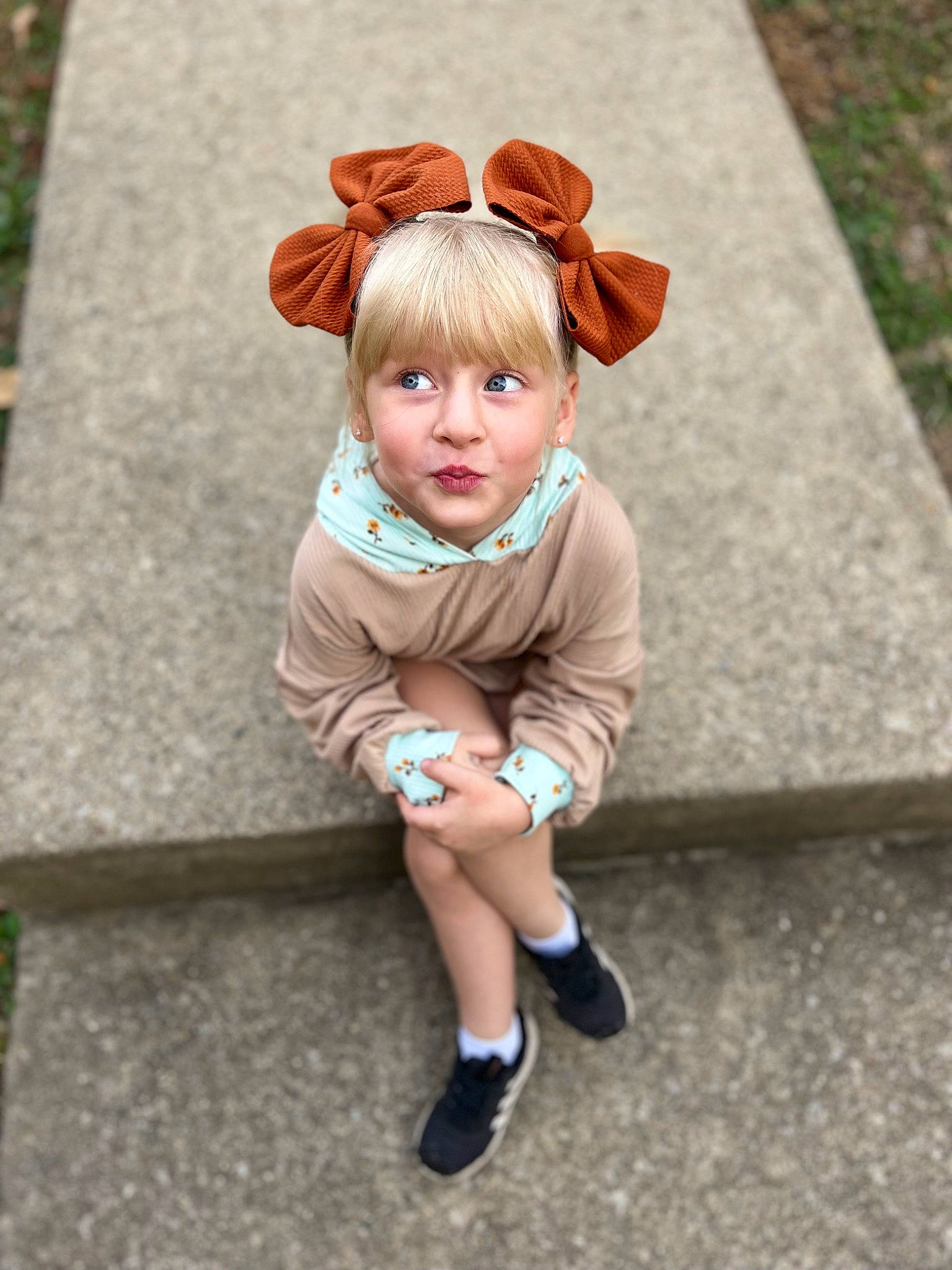 Hadleigh is registered to the contest to win money with this photo: baby_toddler_clothing, bangs, child, eye, face, fawn, grass, hair, happy, head, human_leg, mammal, people_in_nature, person, plant, sitting, sleeve, sock, toddler, vertebrate