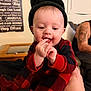 August joined the competition — help win amazing prizes! baby, infant, child, beanie, hat, red_plaid, onesie, pajamas, hands, fingers, chewing, smile, couch, living_room, adult_arm, tattoo, window_blinds, wall_art, wooden_table, portrait