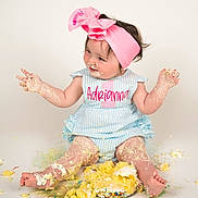 Adrianna joined the competition — help win amazing prizes! baby, child, cake, messy, pink_bow, blue_outfit, birthday, sitting, smiling, face, legs, hands, frosting, crumbs, white_background, cute, celebration, portrait, one_year, fun