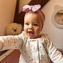 Romy participe au concours pour gagner de l'argent avec cette photo : baby, child, infant, headband, pink_bow, onesie, floral_pattern, smiling, happy, cute, portrait, indoor, teddy_bear, soft_lighting, cozy, reaching_out, face, expression, warm, blurred_background