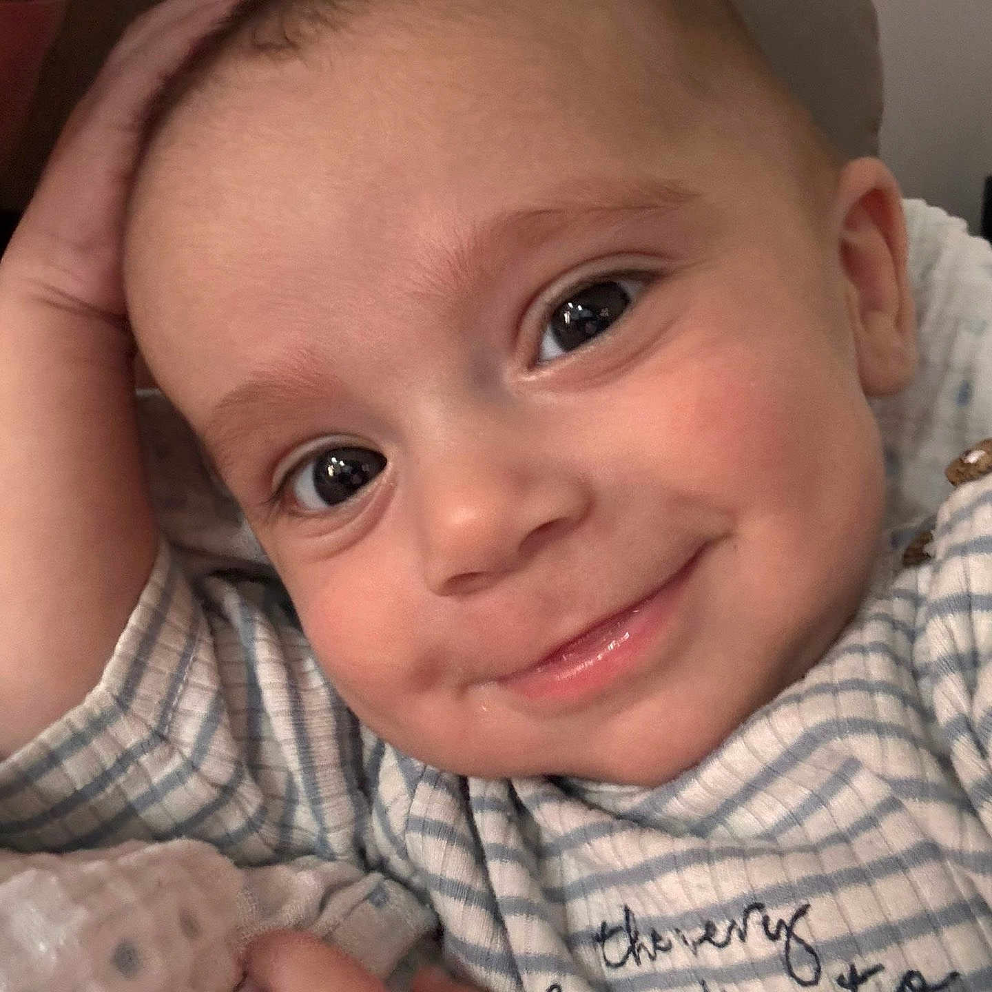 Elijah joined the competition — help win amazing prizes! baby, child, close_up, cozy, cute, expression, eyes, face, hand, happy, indoors, infant, person, portrait, resting, skin, smiling, soft, striped_clothing, young_child