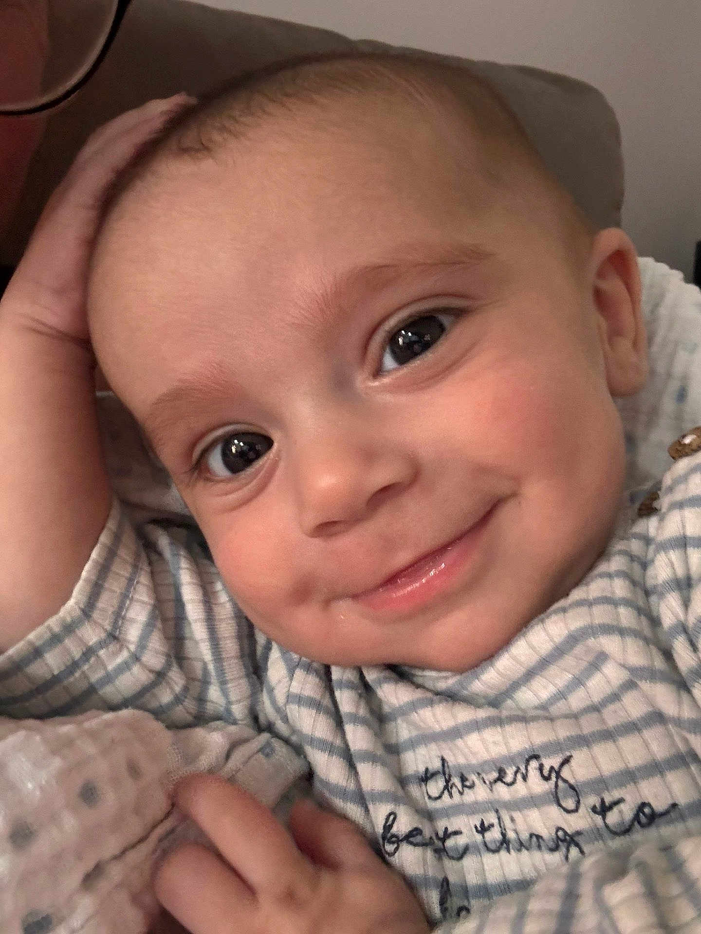 Elijah joined the competition — help win amazing prizes! baby, smiling, close_up, face, infant, child, eyes, hand, striped_clothing, cute, happy, portrait, young_child, skin, person, indoors, cozy, soft, expression, resting