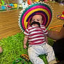 baby, child, colorful, floor, fun, green_mat, group, indoor, music_instrument, mustache, pants, people, person, playmat, playtime, sitting, sombrero, striped_shirt, toddler, toy