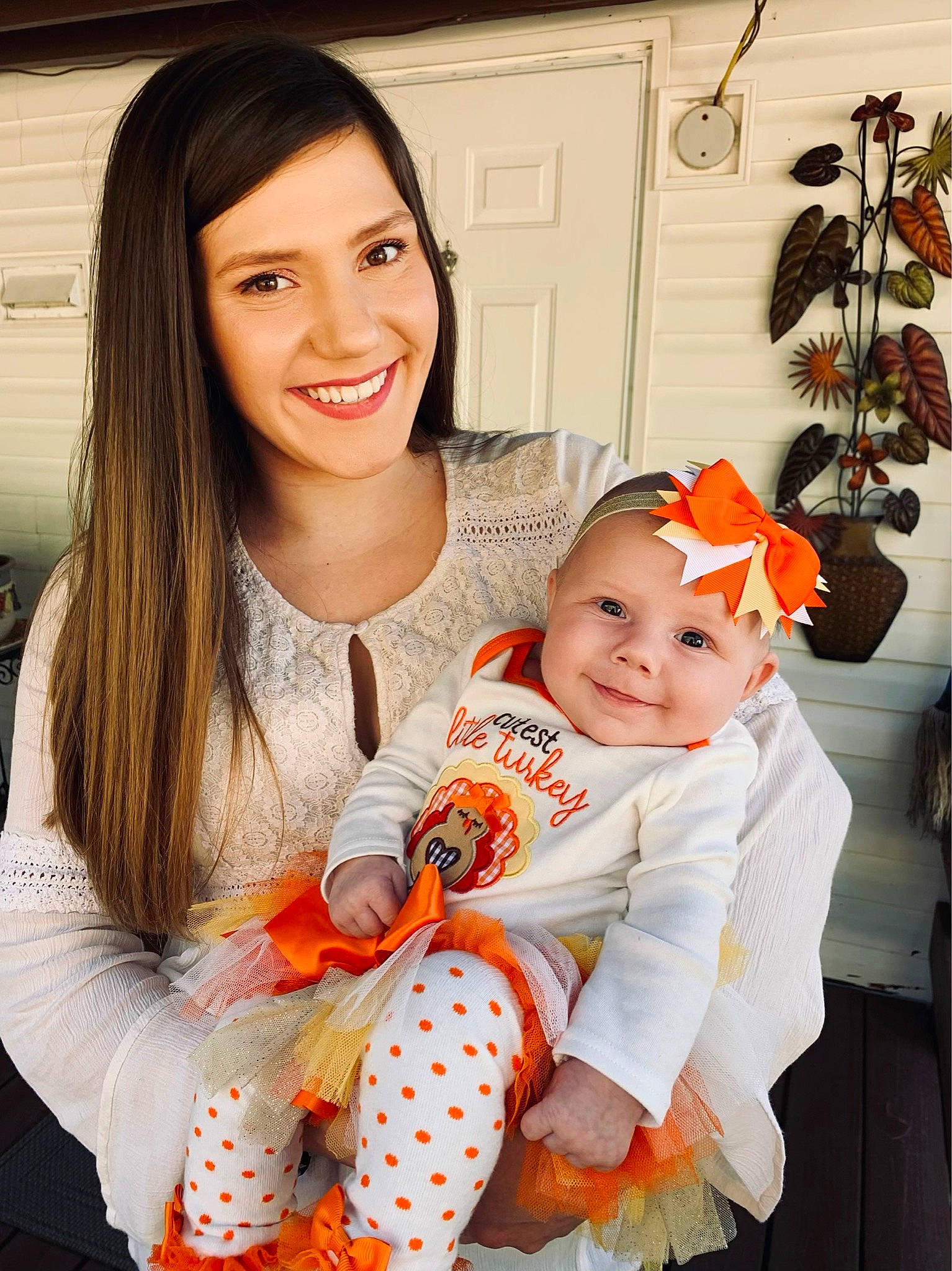 Raina is registered to the contest to win money with this photo: baby, baby_toddler_clothing, event, eye, face, facial_expression, happy, headwear, houseplant, joy, orange, outerwear, people, person, photograph, picture_frame, plant, skin, sleeve, smile