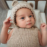 Shâyân joined the competition — help win amazing prizes! baby, infant, knitted_hat, bear_ears, knitted_sweater, cute, child, portrait, indoor, cushion, wooden_bed, neutral_colors, curious_expression, small_hands, closeup, soft_lighting, cozy, newborn, face, lying_down